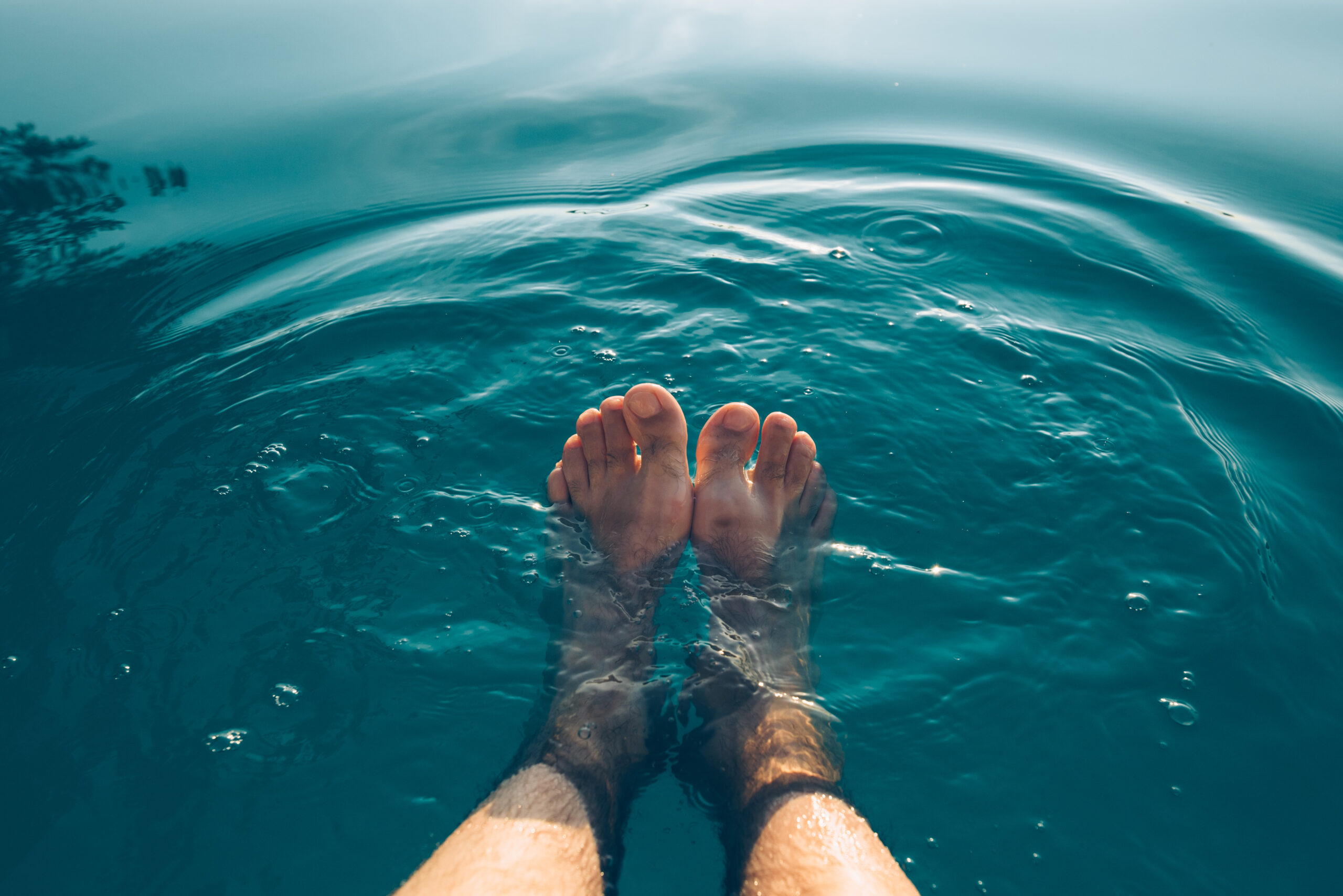 Male feet in outdoor swimming pool